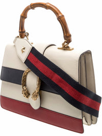 YoloLuxe Handbags off-white leather bag with bamboo handle, navy and red stripes, and antique-gold tiger head closure.