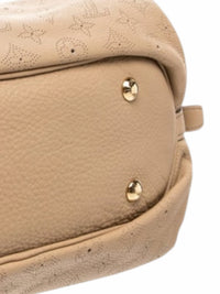YoloLuxe Handbags beige perforated leather hobo bag base with gold-tone protective feet and monogram detailing.