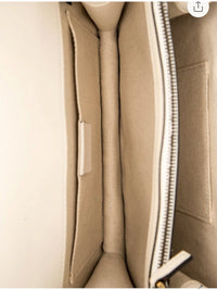 Interior view of YoloLuxe Handbags Gucci bamboo bag featuring beige fabric lining, side pockets, and a zipper closure.