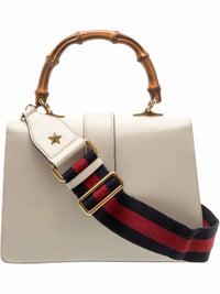 YoloLuxe Handbags off-white leather structured bag with bamboo top handle and navy and red striped shoulder strap.