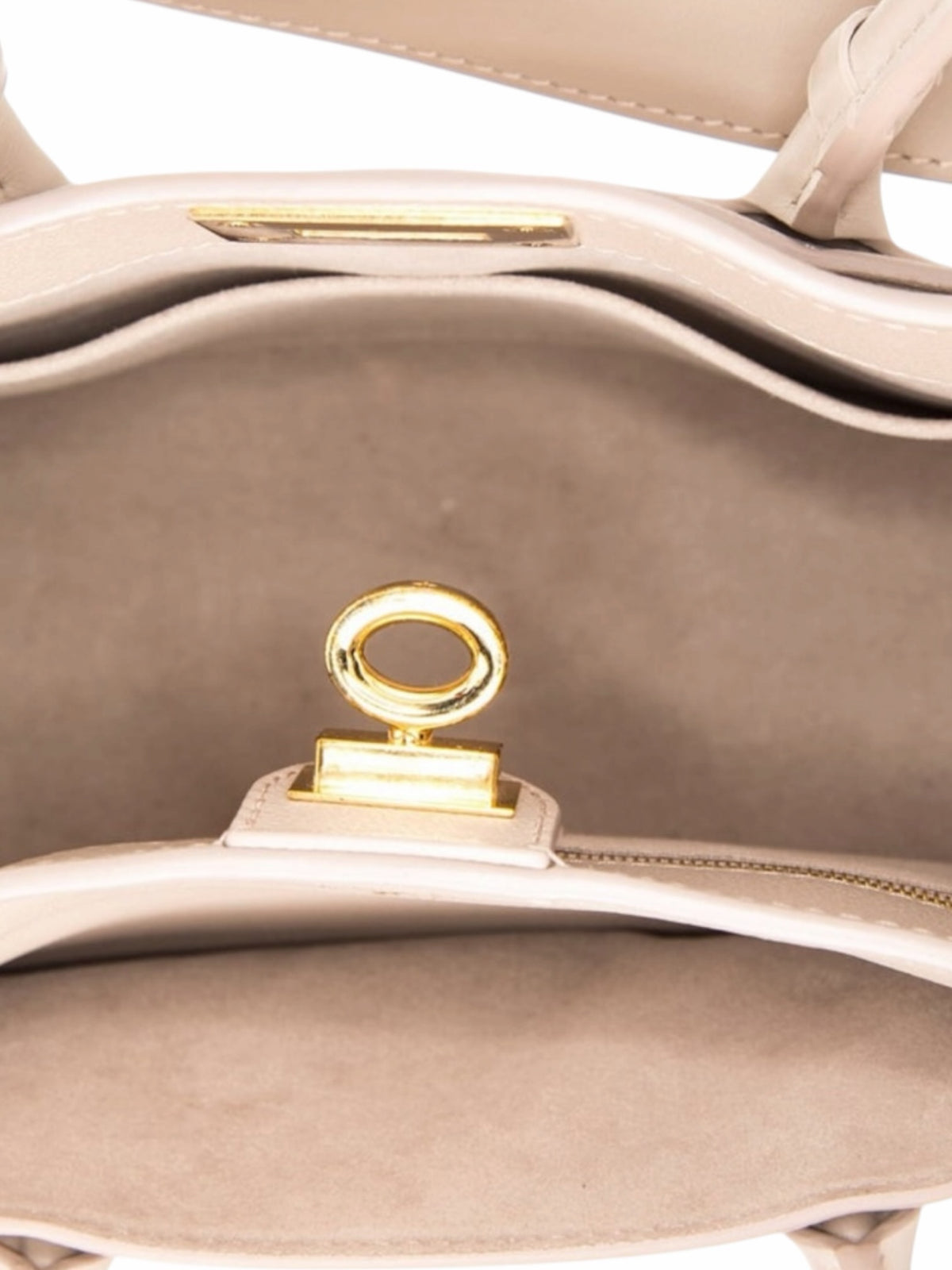Interior of a YoloLuxe Handbags taupe leather handbag featuring a gold-tone turn-lock closure and suede lining