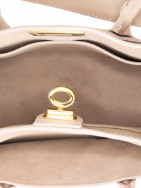 Interior of a YoloLuxe Handbags taupe leather handbag featuring a gold-tone turn-lock closure and suede lining